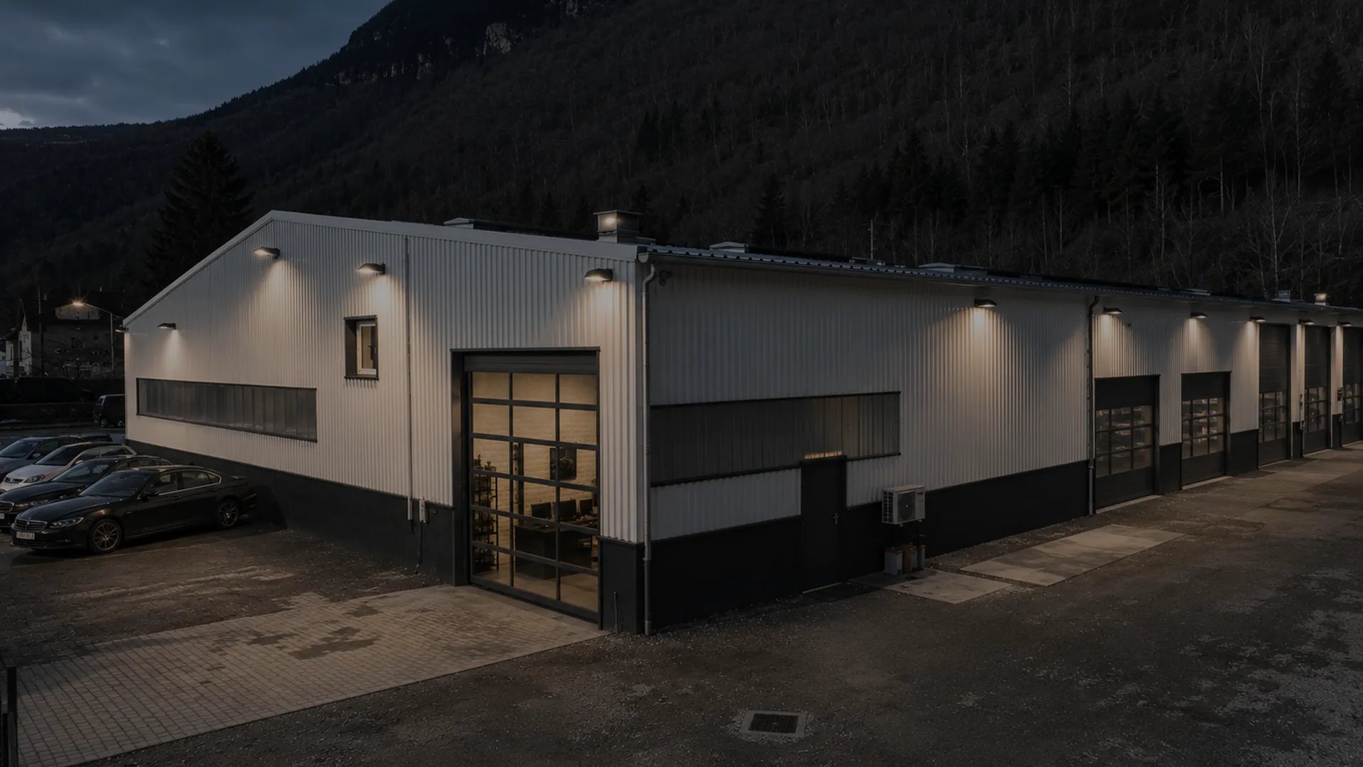 Atelier Helveticar à Saint-Claude (Jura) — bâtiment de reconditionnement éclairé au crépuscule